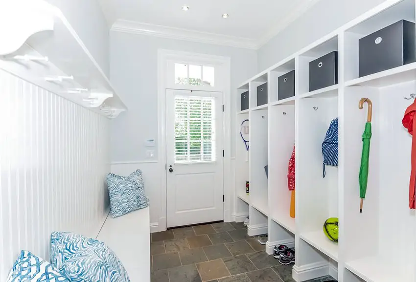 Narrow mudroom with blue accent throw pillows and glass paneled door