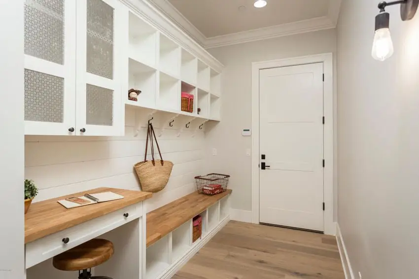 Linear mudroom with off-white walls and pale wood flooring