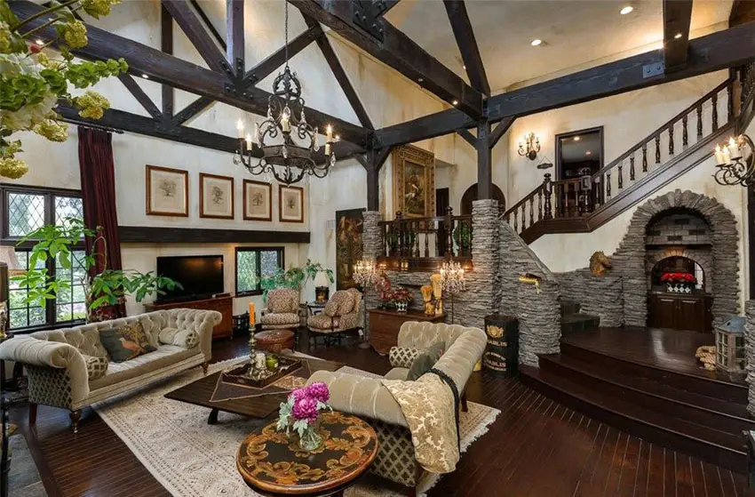 Room with cathedral type ceiling, off white painted walls and wood columns
