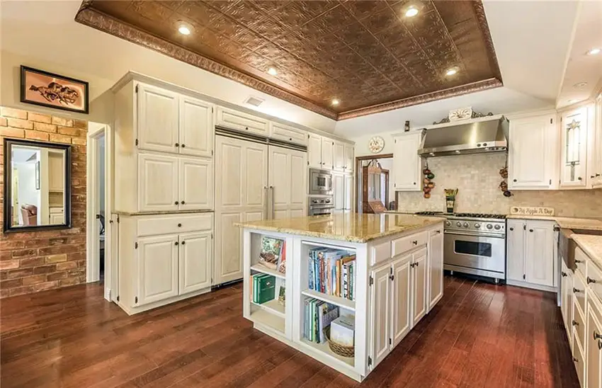 Kitchen with integrated refrigerator, vaulted ceiling and island with shelving