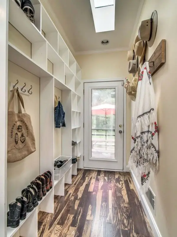 Mudroom with different hats on the walls and several cowboy boots on the shelves