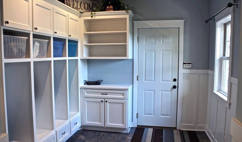Mudroom with blue and white theme, wainscoting and built in cabinet
