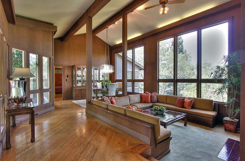 Room with red oak floors, u-shaped bench seats and orange pillow