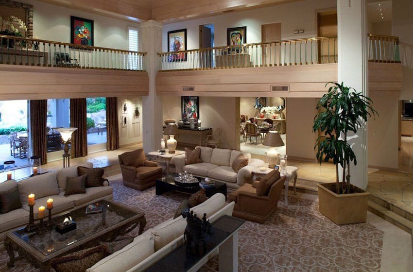 Room with second floor balcony, potted plant, brown walls and couches