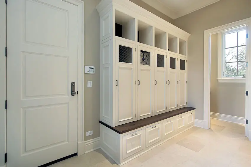 Mudroom casework with recessed panelling and bench with surface with dark finish