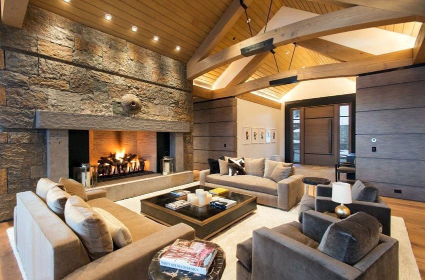 Brown themed contemporary sitting room with stone block fireplace and vaulted design ceiling