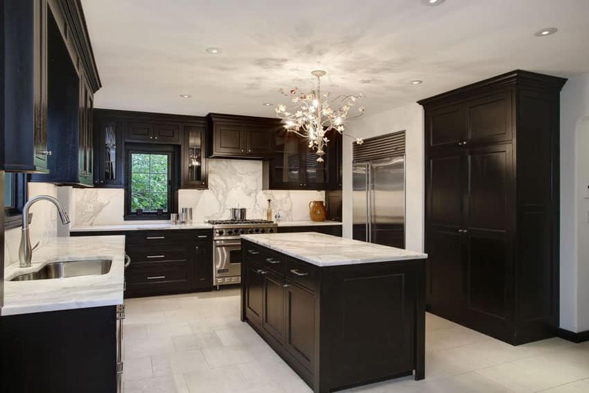Contemporary kitchen with black cabinets, marble counter backsplash and chandelier