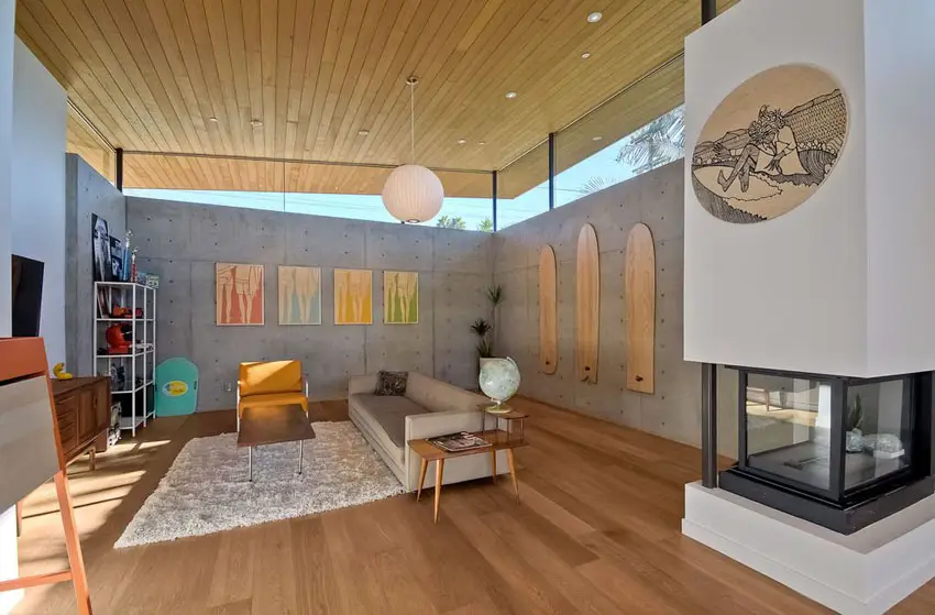 Contemporary living room with concrete walls wood flooring and high glass windows