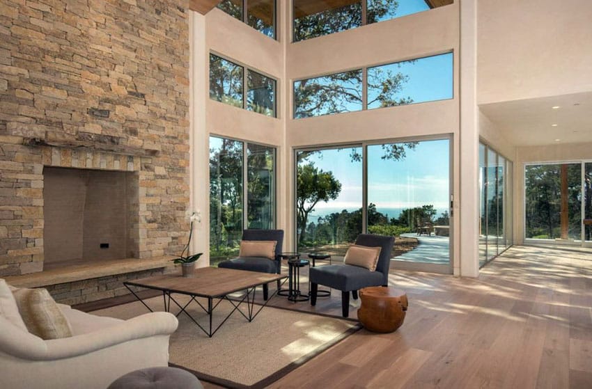 Contemporary living room with high ceilings engineered wood floors and stone fireplace