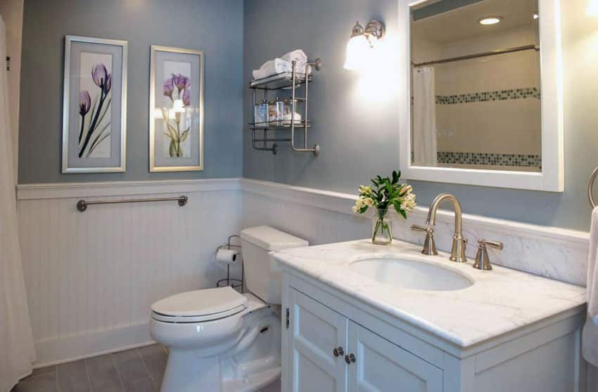 Cottage bathroom with plank wainscoting, blue paint and marble sink countertop