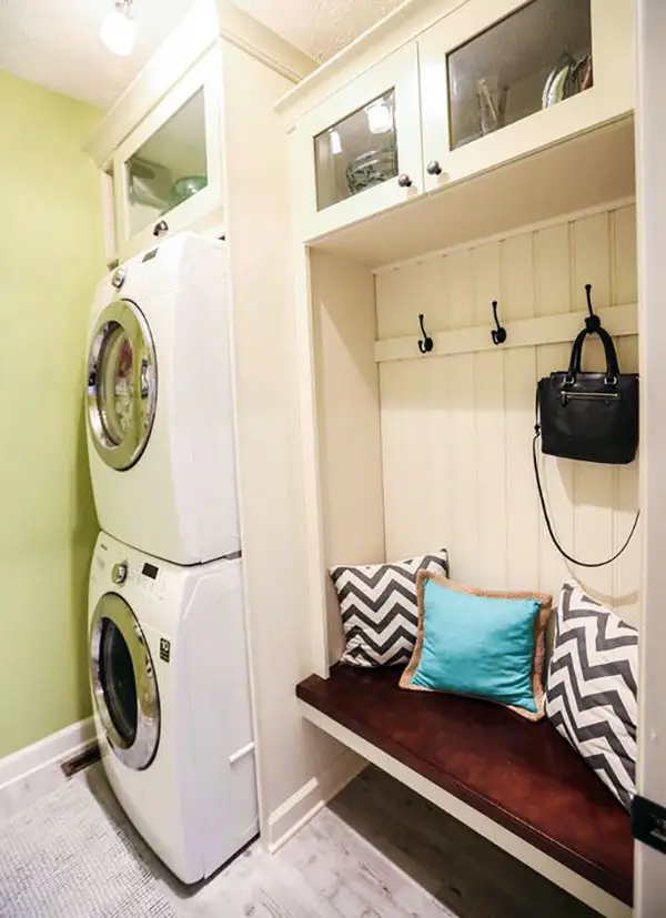 Cozy mudroom bench with clothing hangers next to washers