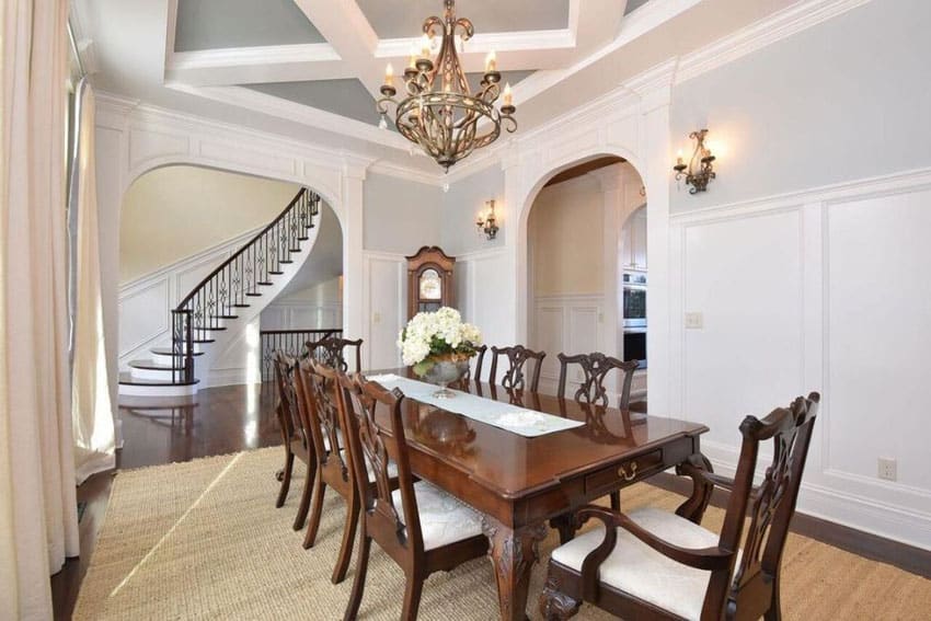 Formal dining room with high white wainscoting and upper gray paint design