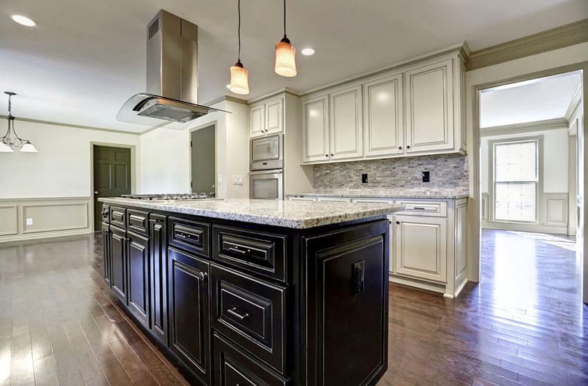 Kitchen with black cabinet island and white main cabinets with white granite countertops