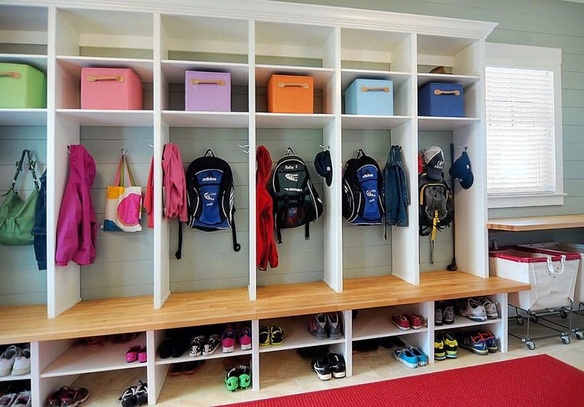 Large mudroom with clothing hangers shoe cubbies and wood bench