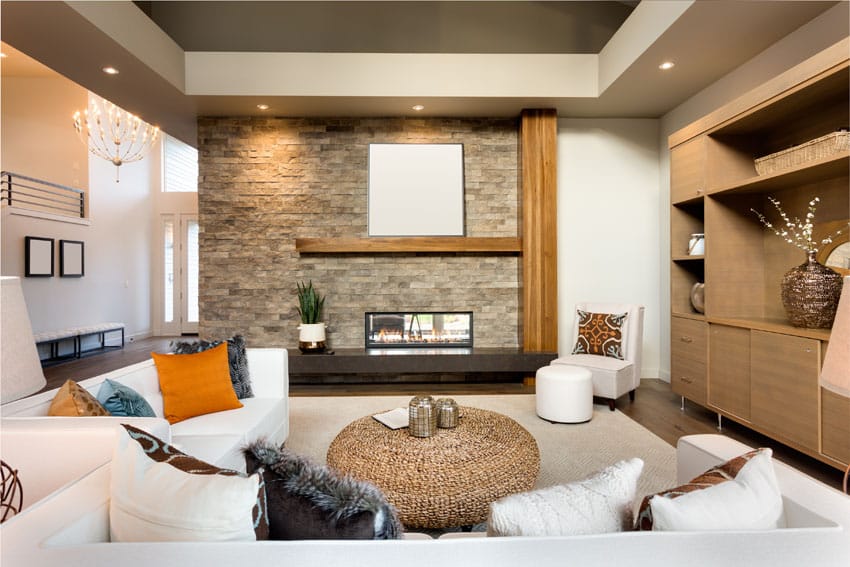 Contemporary living room with stacked stone fireplace and built-in bookshelves
