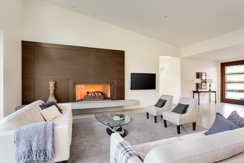Contemporary living room with white furniture and brown accent wall fireplace