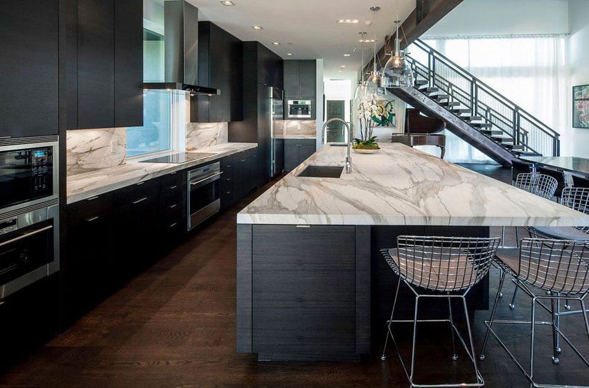 Kitchen with marble countertops and backsplash and steel stools