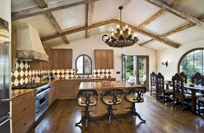 Mediterranean kitchen with rosewood granite countertops and wood beam cathedral ceiling