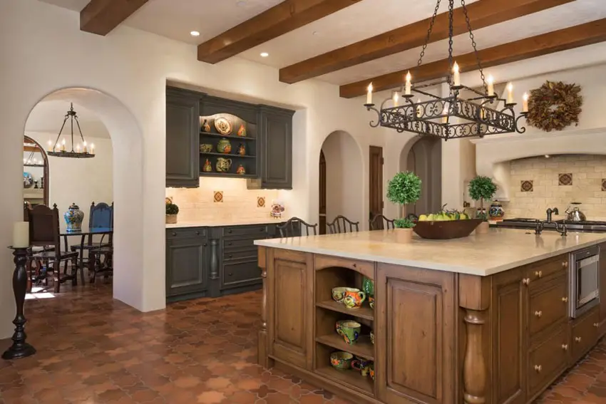 Kitchen with terracotta flooring ornamental ceiling beams and weathered panel cabinets