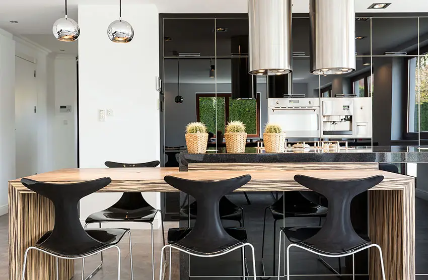 Modern black cabinet kitchen with wood grain island and chrome lighting