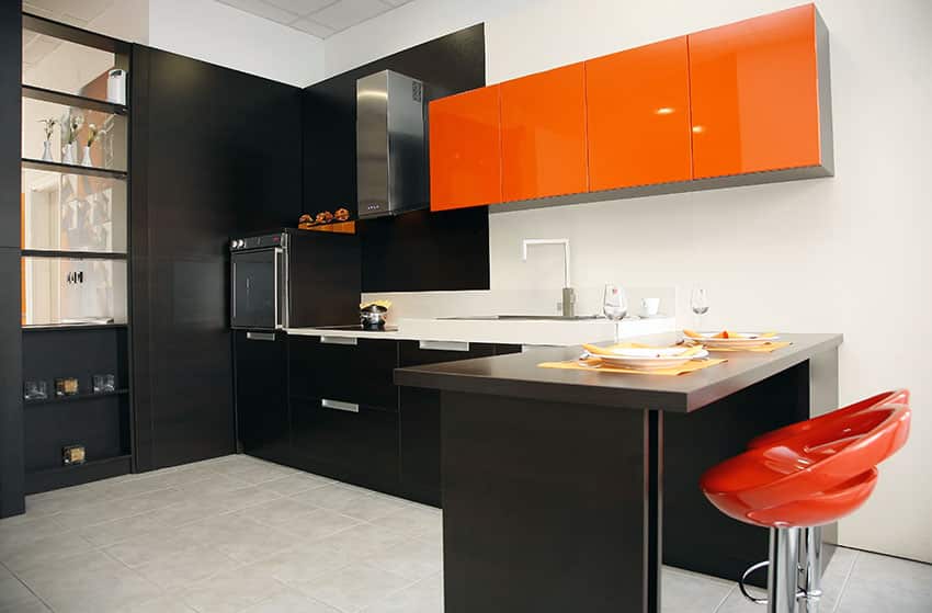 Kitchen with black drawers and red cabinets with red bar stools