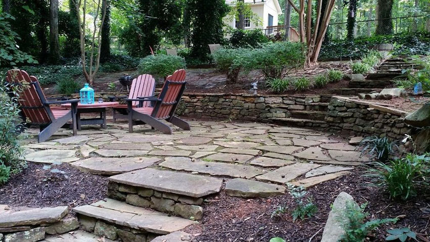 Rustic cut stone backyard patio with stone steps