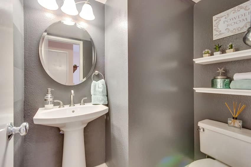 Powder room with round mirror and above sink shelves