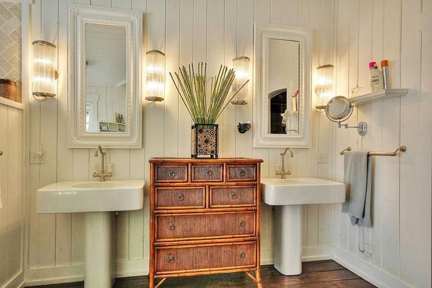 Small bathroom with central wood storage cabinet between two sinks