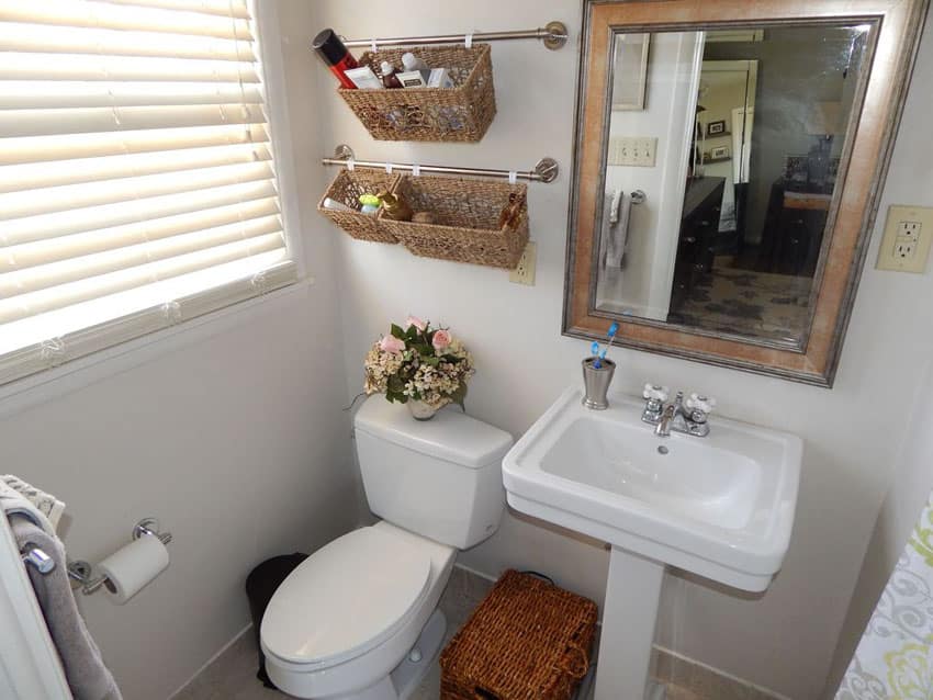 Small bathroom with wall mounted towel bar and hanging basket storage
