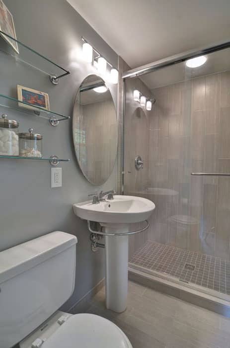 Bathroom with slate wall tiles, porcelain flooring and glass shelving