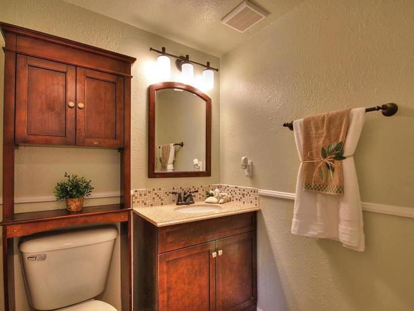 Small craftsman style bathroom with over toilet storage cabinet