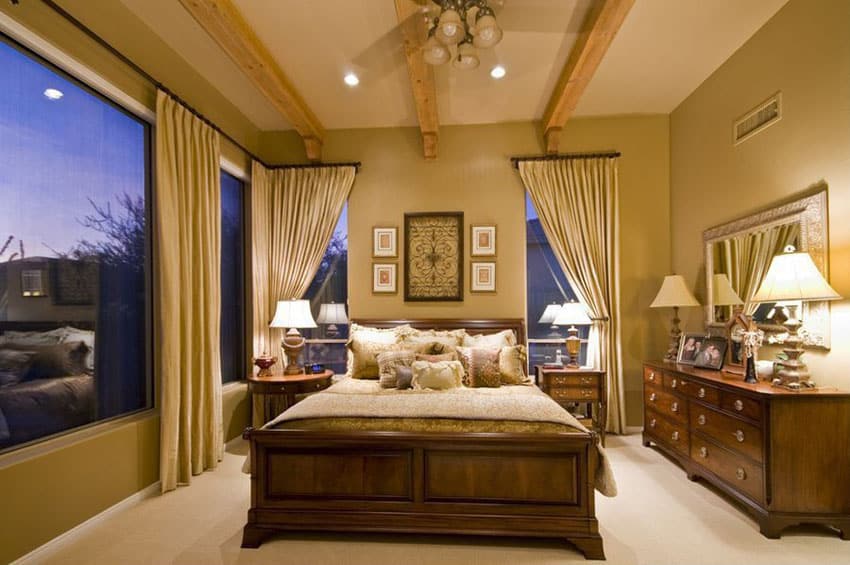 Tan color bedroom with wood furniture and exposed beam ceiling