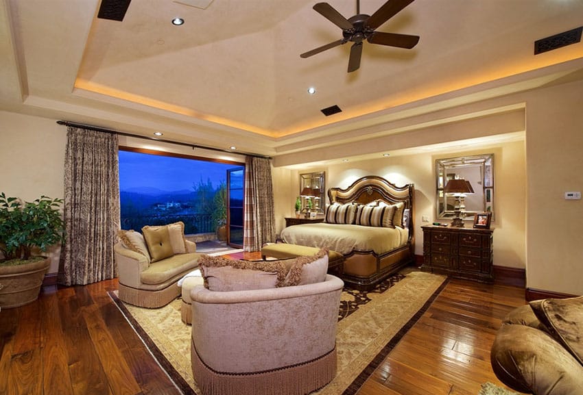 Tan luxury master bedroom with wood floors and outdoor balcony