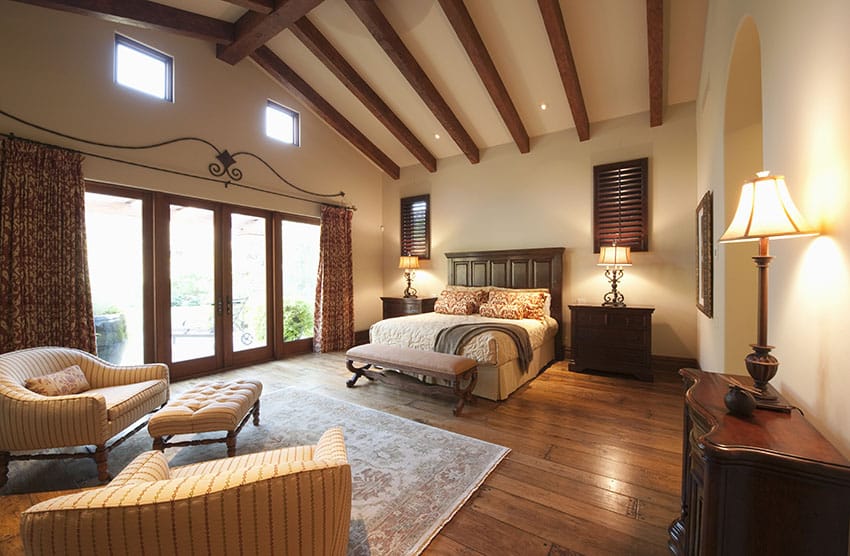 Tan painted bedroom with vaulted ceiling and exposed beams