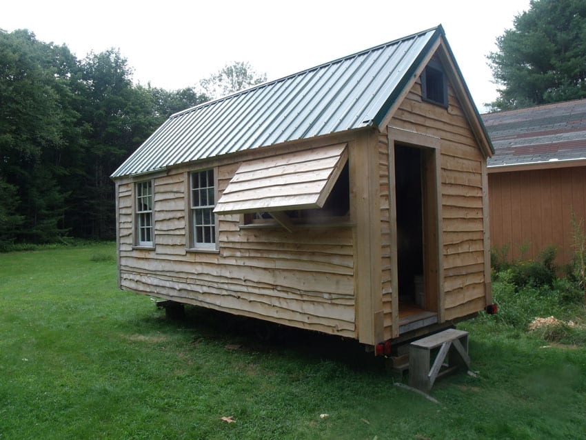 Tiny house with rough wood siding and metal roof