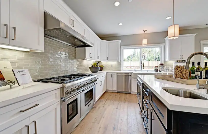Traditional kitchen with white cabinets quartz and glass subway tile