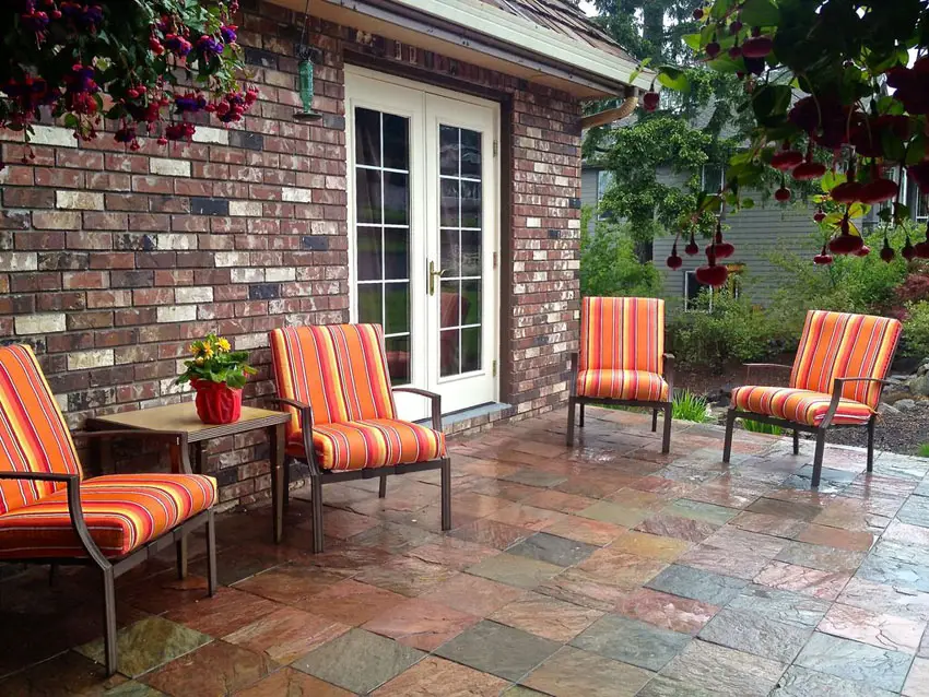 House with brick walls, French doors and orange outdoor chairs