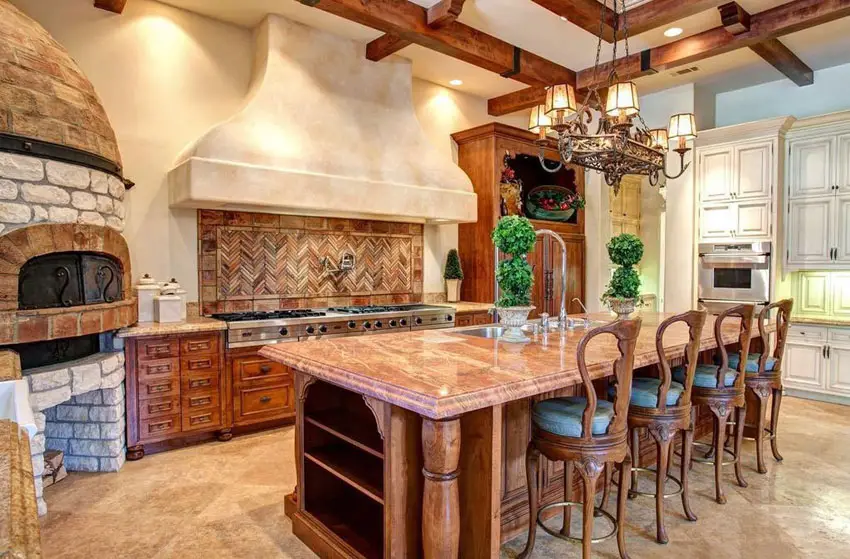 Kitchen with long dining island commercial grade cooktop and antique style backsplash