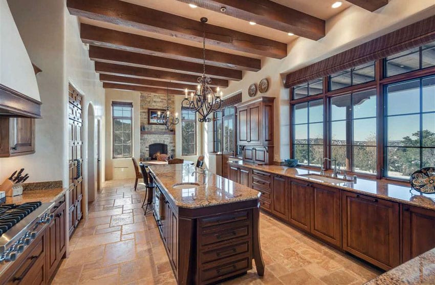 Tuscan kitchen with gold granite counters narrow island and travertine flooring