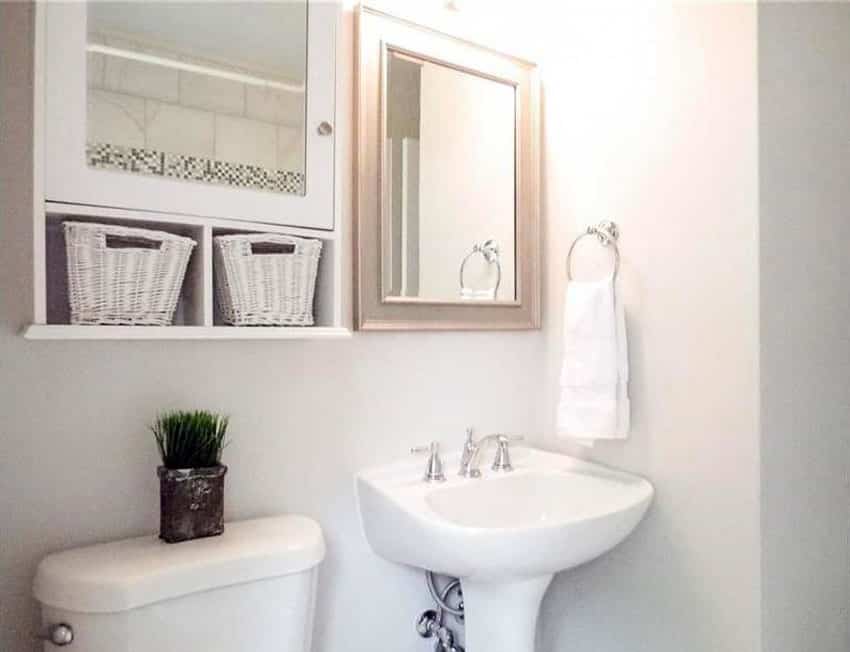 White bathroom with medicine cabinet with wicker baskets