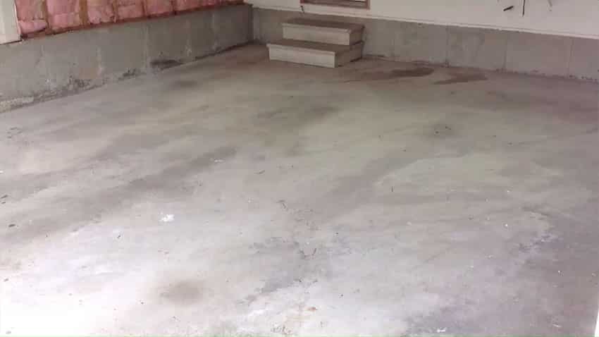 Bare garage flooring before the makeover image
