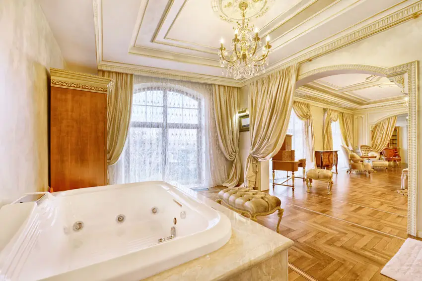 Bathroom with gold decor, chandelier, wood flooring and whirlpool tub