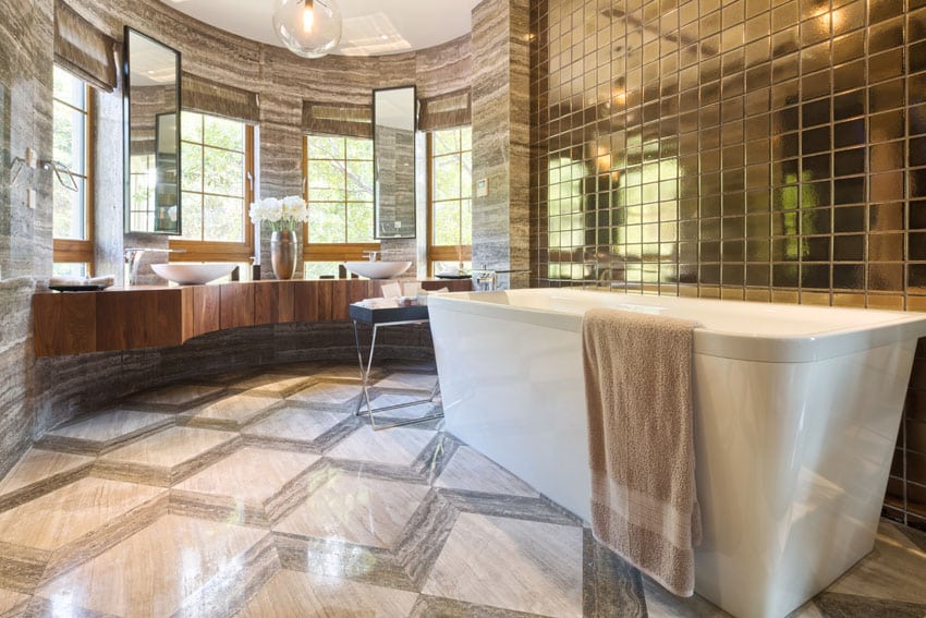 Bathroom with gold mosaic tile above bathtub, vessel sinks and contemporary vanity