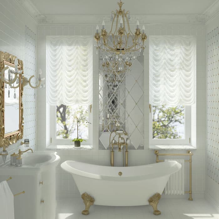 Beautiful gold and white bathroom with clawfoot tub and chandelier