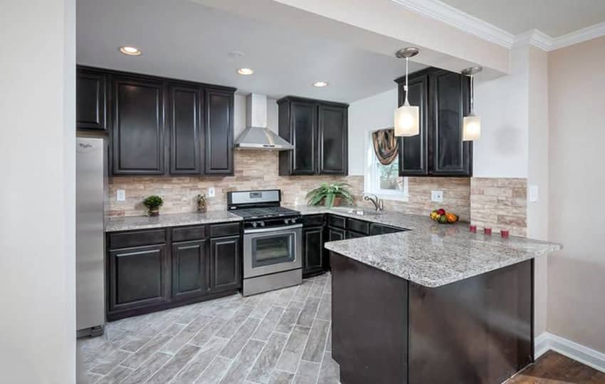 J-shaped kitchen with light granite countertops and stainless steel appliances