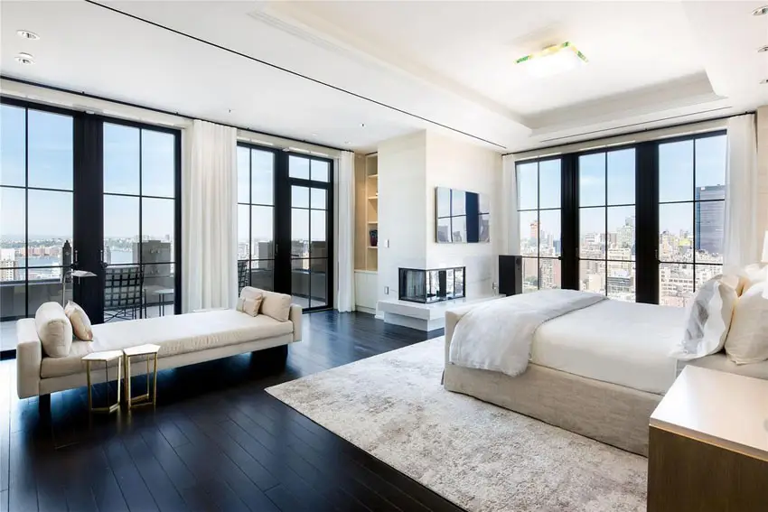 Contemporary master bedroom with dark oak floors and city views