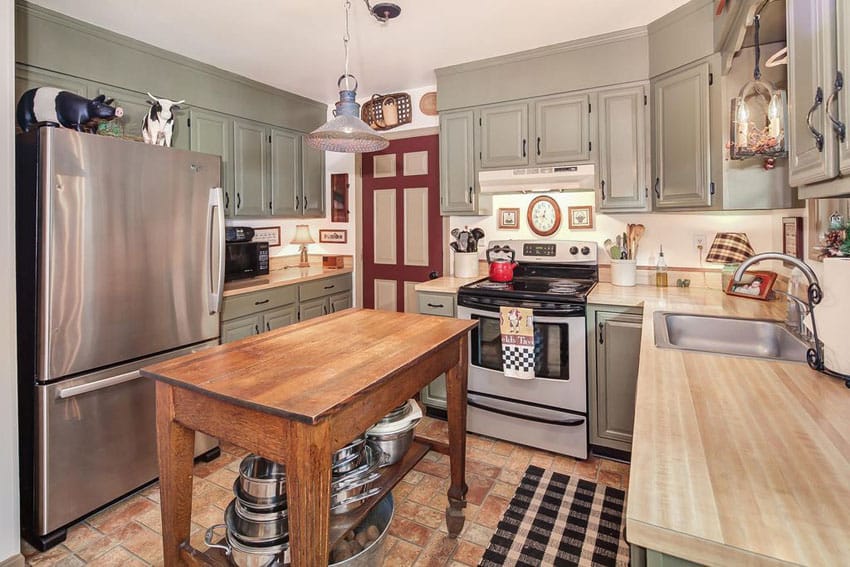 Country kitchen with green cabinets wood counter and rustic portable wood island