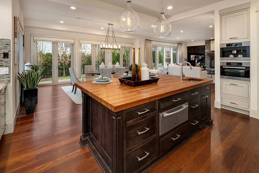 Kitchen island with wood countertop, dark cabinet and hickory floors