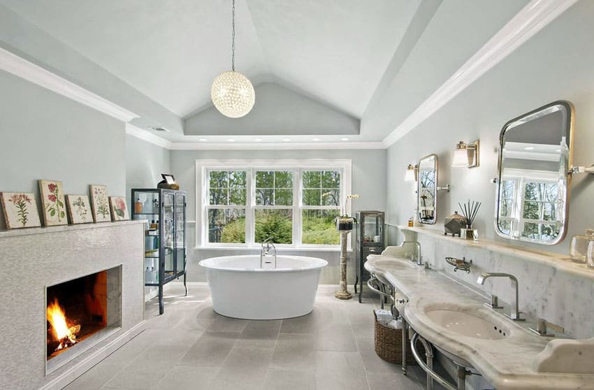 bathroom with fireplace, freestanding tub, porcelain floors and ball chandelier