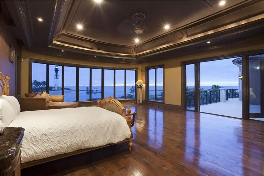 Luxury master bedroom with dark oak flooring and ocean views